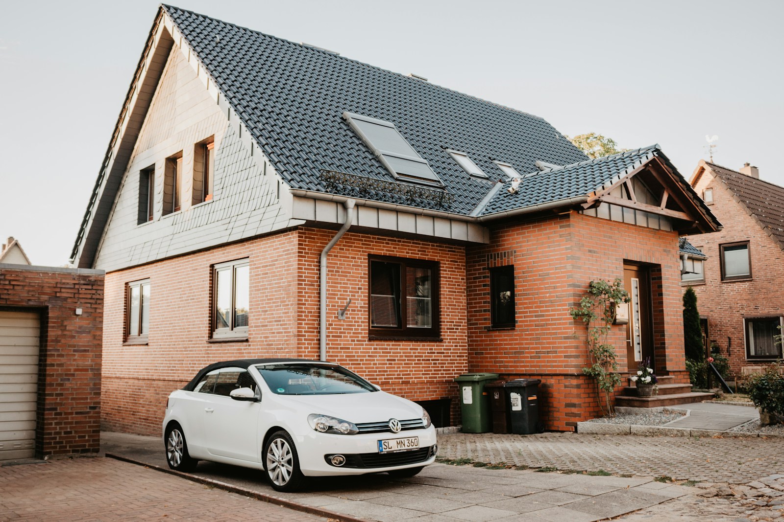 white Volkswagen Jetta parked beside house with auto and home insurance